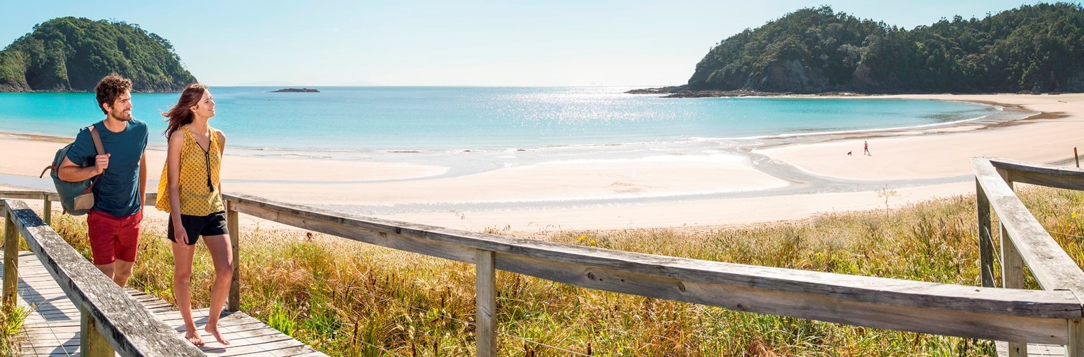 Tourists walking by Matapouri Bay