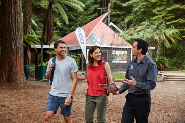 Two tourists outside Redwoods Forest iSITE with iSITE guide